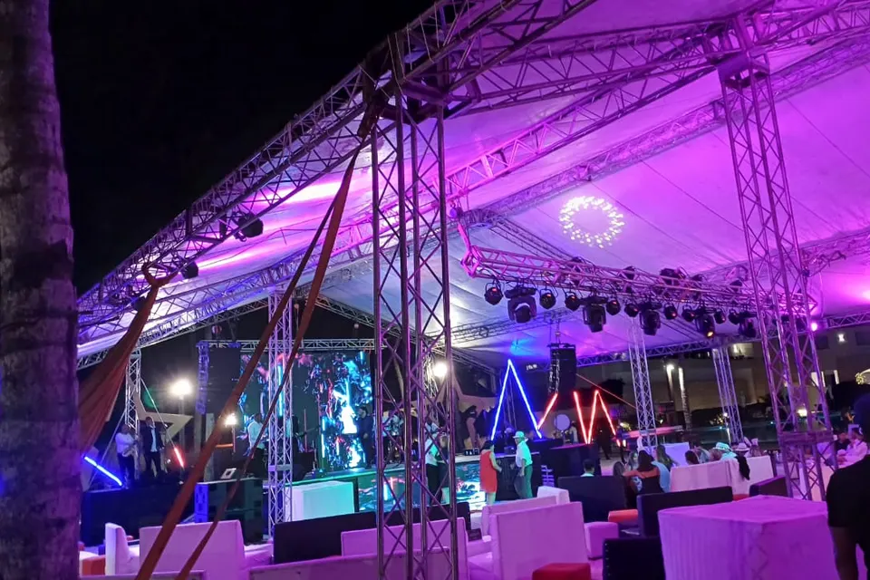 Montaje nocturno con techo truss e iluminación ambiental violeta